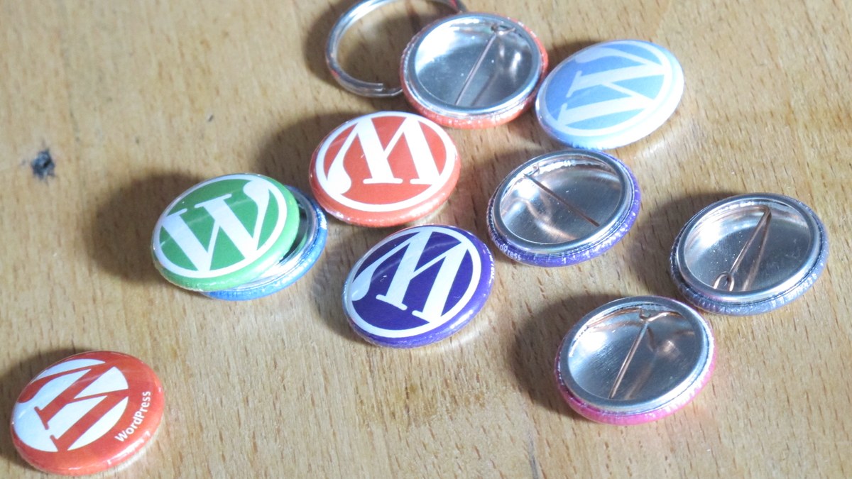 Masa üzerinde WordPress logolu renkli rozetler (temsili görsel)